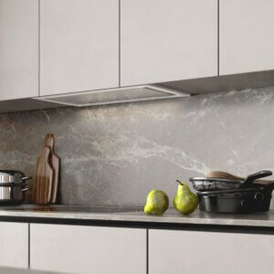 Kuchnia z okapem podszafkowym i naczyniami na blacie.