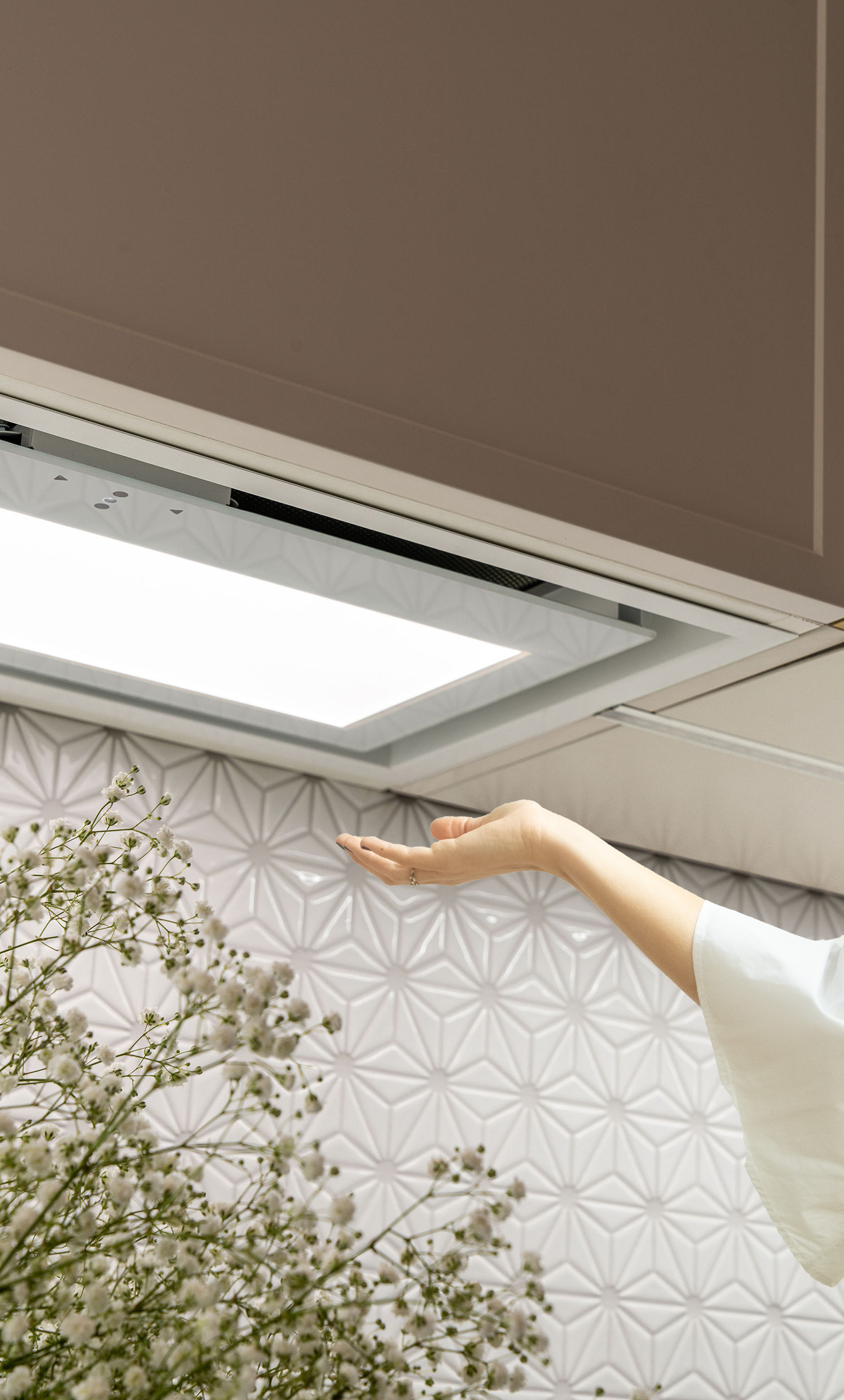 Ręka pod okapem kuchennym z oświetleniem.